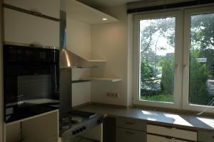 a kitchen with a large window and a stove top oven at Ruhiges Haus mit privatem Garten in Halstenbek