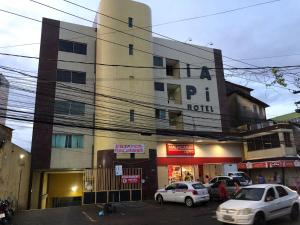 un edificio con coches estacionados frente a él en Iapi Hotel, en Salvador