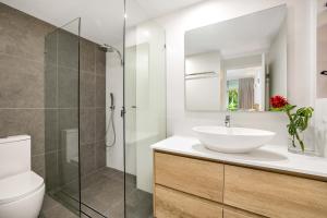 a bathroom with a sink and a glass shower at Oasis at Palm Cove in Palm Cove