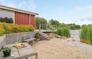 a patio with a bench and a building and water at Awesome Home In Vemb With 2 Bedrooms And Wifi in Vemb