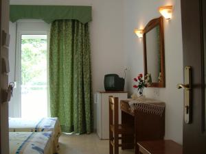 a bedroom with a window and a bed and a mirror at Estelle Hotel in Gerakini