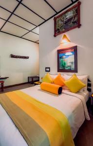 a bedroom with a large bed with yellow pillows at Train View Chalet in Bandarawela