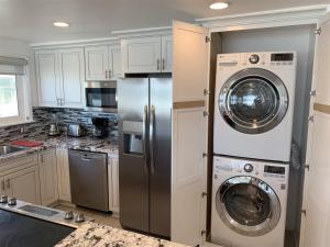 a kitchen with a refrigerator and a washer and dryer at 120-oceanfront Penthouse 5 in San Diego