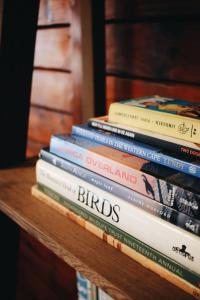 una pila di libri seduti su un tavolo di The Wild Edge Last Light Cottage a Knysna