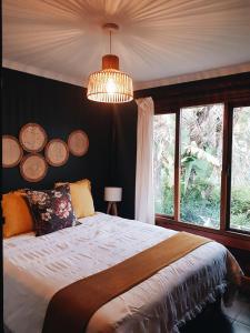 ein Schlafzimmer mit einem Bett und einem großen Fenster in der Unterkunft The Wild Edge Last Light Cottage in Knysna