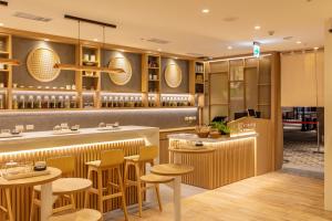 CHO Stay Capsule Hotel-Taoyuan Airport T2 في دايوان: مطعم مع بار وكراسي