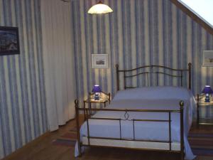1 dormitorio con cama y pared a rayas en Gite Le Mascaret, en Roz-sur-Couesnon