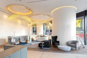vestíbulo con sillas y lámparas de araña en un edificio en CASSA ONE - Luxury Apartments Managed by The Cassa en Brisbane