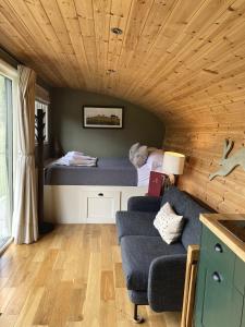a bedroom with a bed and a couch in a room at Hares Retreat - Middle Cabin in Foolow