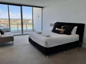 a bedroom with a large bed with a large window at Bayview 705 in Mandurah