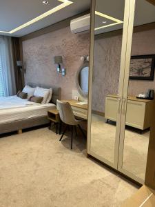 a bedroom with a bed and a table and a mirror at City Park INN - Art Studio in Plovdiv
