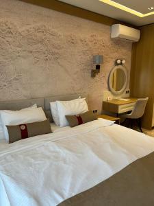 a bedroom with a large white bed and a mirror at City Park INN - Art Studio in Plovdiv
