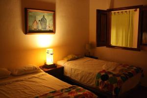 een slaapkamer met 2 bedden en een foto aan de muur bij Bungalow Casa de los Abuelos in Lo de Marcos