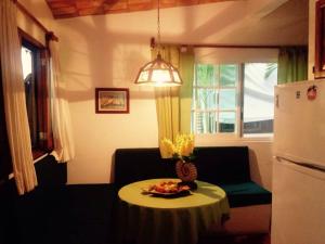 een woonkamer met een tafel en een koelkast bij Bungalow Casa de los Abuelos in Lo de Marcos