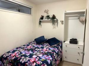 1 dormitorio con 1 cama con colcha de flores en Onsite Parking, Self Check-in en Melbourne