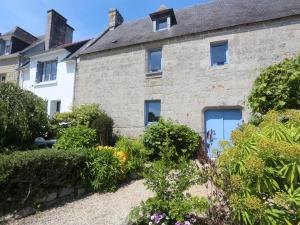 an old stone house with bushes in front of it at Combrit Sainte-Marine: T2 duplex rénové avec jardin privé et vue sur port - FR-1-481-91 in Combrit