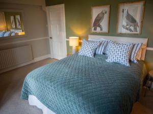 a bedroom with a large bed with a blue comforter at The Beeches - Chatsworth Apartment No 1 - Sleeps 2 in Baslow