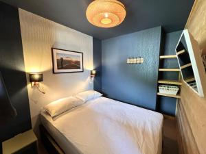 a bedroom with a bed and a blue wall at VUE PANORAMIQUE & RÉNOVÉ CENTRE STATION 1800 - 2 Chambres - 6 PERS in Les Orres