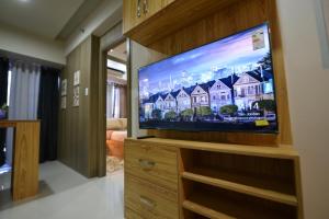 uma grande televisão de ecrã plano numa sala de estar em Condo in Pasay em Manila