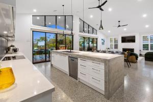 cocina grande con armarios blancos y sala de estar. en Rio Vista - Luxury Accommodation, en Rye