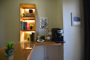 a counter with a coffee maker and a book shelf at Condo in Pasay in Manila
