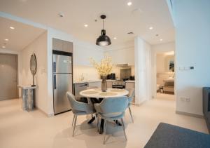 a kitchen and dining room with a table and chairs at Nasma Luxury Stays - The Grand, Dubai Creek Harbour in Dubai