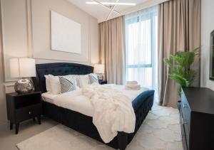a bedroom with a bed with a blanket on it at Nasma Luxury Stays - The Grand, Dubai Creek Harbour in Dubai