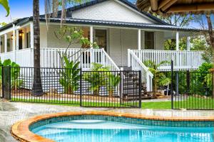 a house with a swimming pool in front of a fence at 4 Bedroom Family Home with Pool - Uplands Drive - Q Stay in Gold Coast
