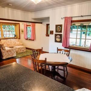 a living room with a table and chairs and a couch at Mulberry Cottage in Mount Tamborine