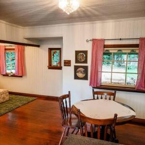 a living room with a table and chairs in it at Mulberry Cottage in Mount Tamborine