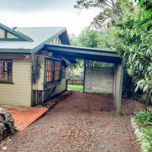 a house with a garage with a fence at Mulberry Cottage in Mount Tamborine