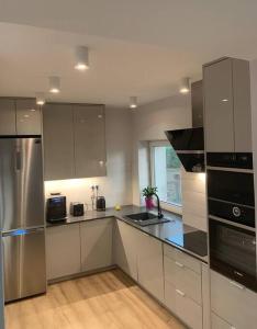 a kitchen with stainless steel appliances and a window at Lapa House in Mrągowo