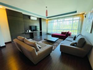 uma sala de estar com um sofá e dois sofás em AA Residen Luxury Condo HOMESTAY 18mins walk Tanjung Aru Beach & GOLF Course, not Beach Side Resort em Kota Kinabalu
