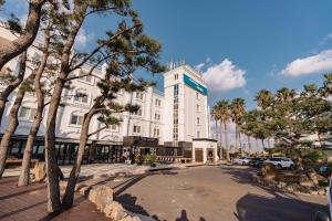 a large white building with a sign on it at Cocoon Hotel in Jeju