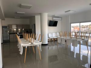 un comedor con mesas blancas y sillas blancas en Departamento de un dormitorio en pleno centro Veneto IV en Villa Carlos Paz