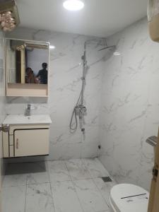 Un baño blanco con ducha y lavabo. en Green Homestay, en Hanói 4 fotos más