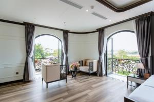 ein Wohnzimmer mit großen Fenstern und einem Sofa in der Unterkunft Khách sạn Robin Gia Nghĩa in Gia Nghĩa