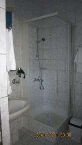 a bathroom with a shower and a tub and a sink at Hotel Alexandros Busteni in Buşteni