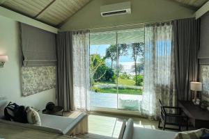 ein Wohnzimmer mit einem großen Fenster mit Meerblick in der Unterkunft Shantaa Resort, Kohkood in Ko Kood