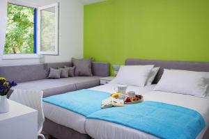 ein Wohnzimmer mit 2 Betten und einem Sofa in der Unterkunft Apartments Aminess Port 9 Residence Korcula - CIN1000d-CYB in Korčula