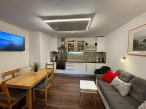 ブリクセン・イム・ターレにあるGorgeous Apartment in Terrace Garden Barbecue Deckchairsのリビングルーム(ソファ、テーブル付)、キッチンが備わります。