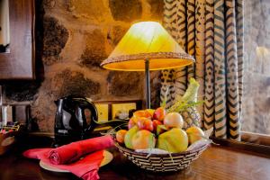 une corbeille de fruits sur une table avec une lampe dans l'établissement Kilaguni Serena Safari Lodge, à Tsavo