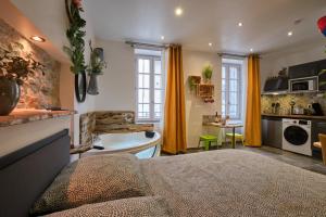a bedroom with a bed and a bathroom with a tub at Place Carnot - studio tout équipé avec jacuzzi proche toutes commodités in Carcassonne +59 photos