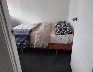 a small bed in a room with a bed sidx sidx sidx at Central Holiday Home in Tauranga