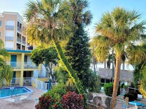 a resort with palm trees and a swimming pool at Searenity, Waterside studio in the heart of Treasure Island, walk to beach in St. Pete Beach