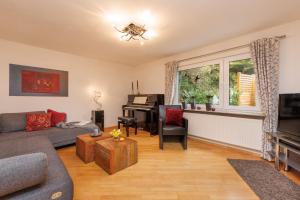 a living room with a couch and a piano at Urlaubsoase im Edertal in Bad Berleburg