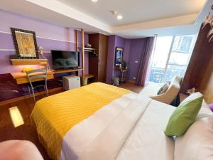 墾丁的住宿－澤信旅店，一间卧室配有一张大床,提供黄色和白色的毯子