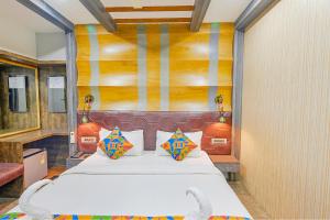 a bedroom with a large white bed with colorful pillows at FabExpress Prime Middleton in Bhubaneshwar