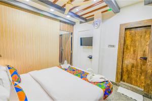 a bedroom with a couch and a wooden door at FabExpress Prime Middleton in Bhubaneshwar