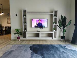 una sala de estar con TV en un estante blanco en Muslim Apartment at The Quintet Cameron Highlands en Cameron Highlands